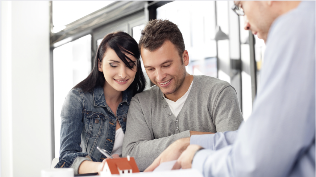 A couple sitting at a table looking over mortgage paperwork with a trusted lender.