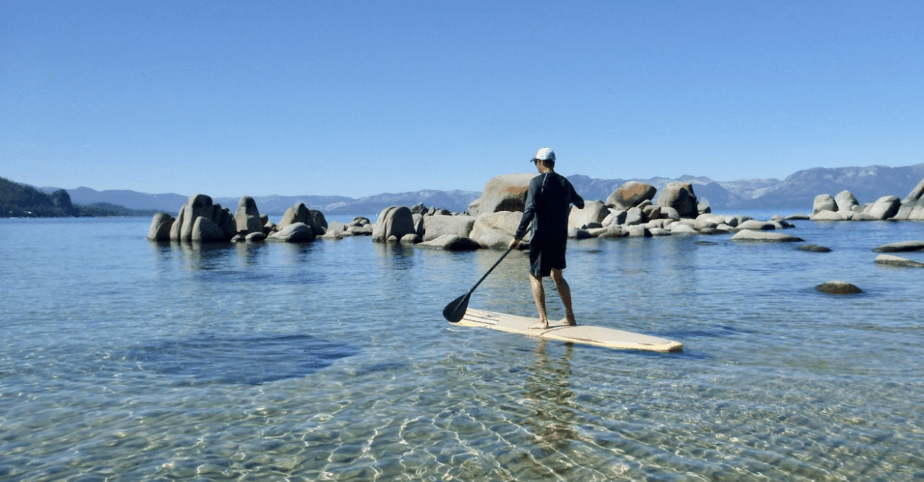 Man paddleboarding in the crystal clear lake tahoe waters